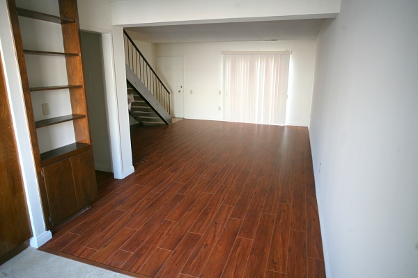 Huge living room with hardwood floor opening to large private patio