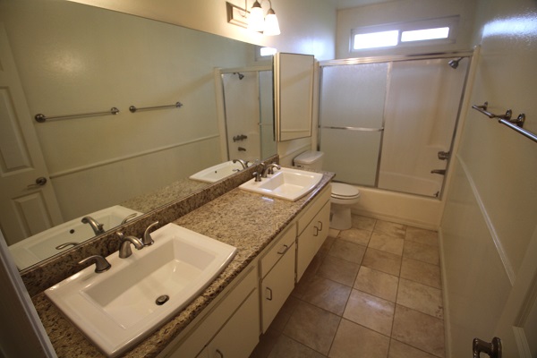 Full Bathroom on second level with two sinks, granite counter and Travertine marble floor