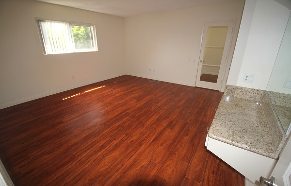 Huge master bedroom with makeup counter, large walk-in closet and hardwood floor